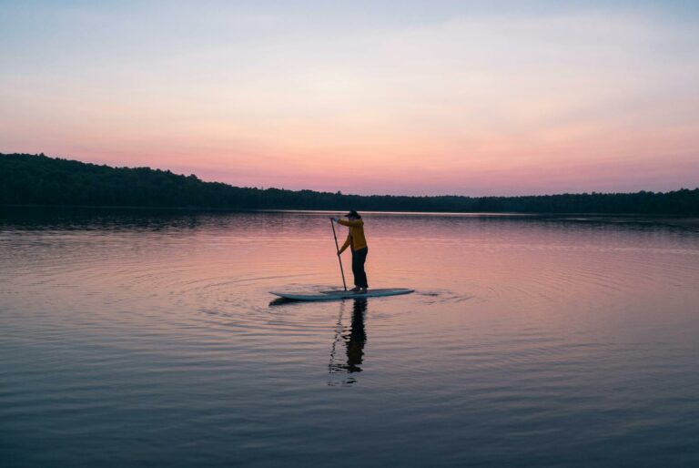 Man Riding Board on Middle of Body of Water